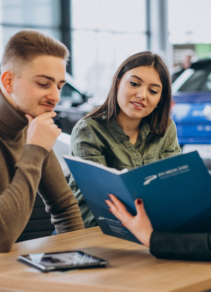 Federal Auto Loan Interest Tax Deduction At Delaney Subaru in Indiana, PA | Person showing a couple a folder of the federal auto loan options available at dealership Federal Auto Loan Interest Tax Deduction At Delaney Subaru in Indiana, PA | Person showing a couple a folder of the federal auto loan options available at dealership