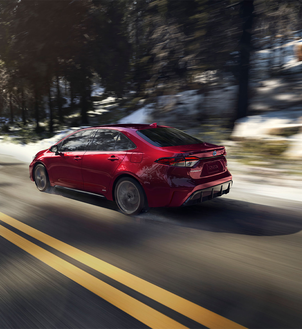 2026 Toyota Corolla at Delaney Toyota of DuBois in DuBois, PA | Rear profile of a red 2026 Toyota Corolla driving down the street