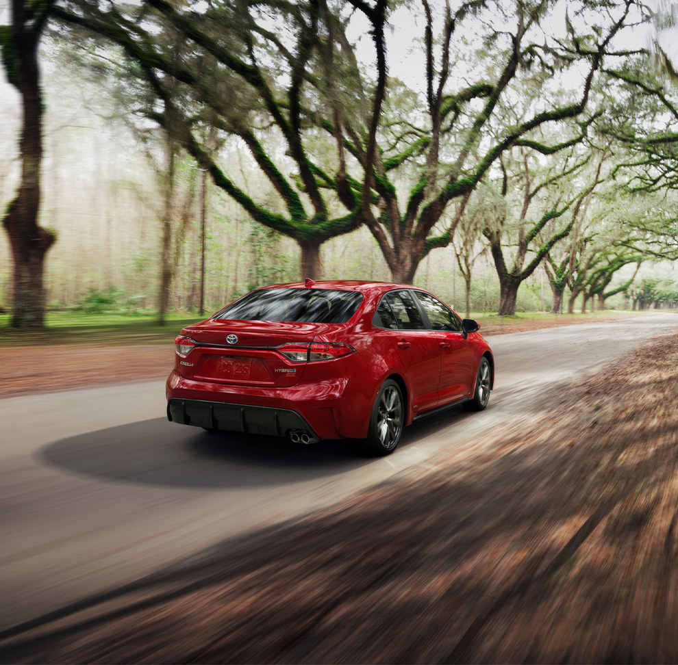 2026 Toyota Corolla at Delaney Toyota of DuBois in DuBois, PA | Rear profile of a red 2026 Toyota Corolla driving down the road