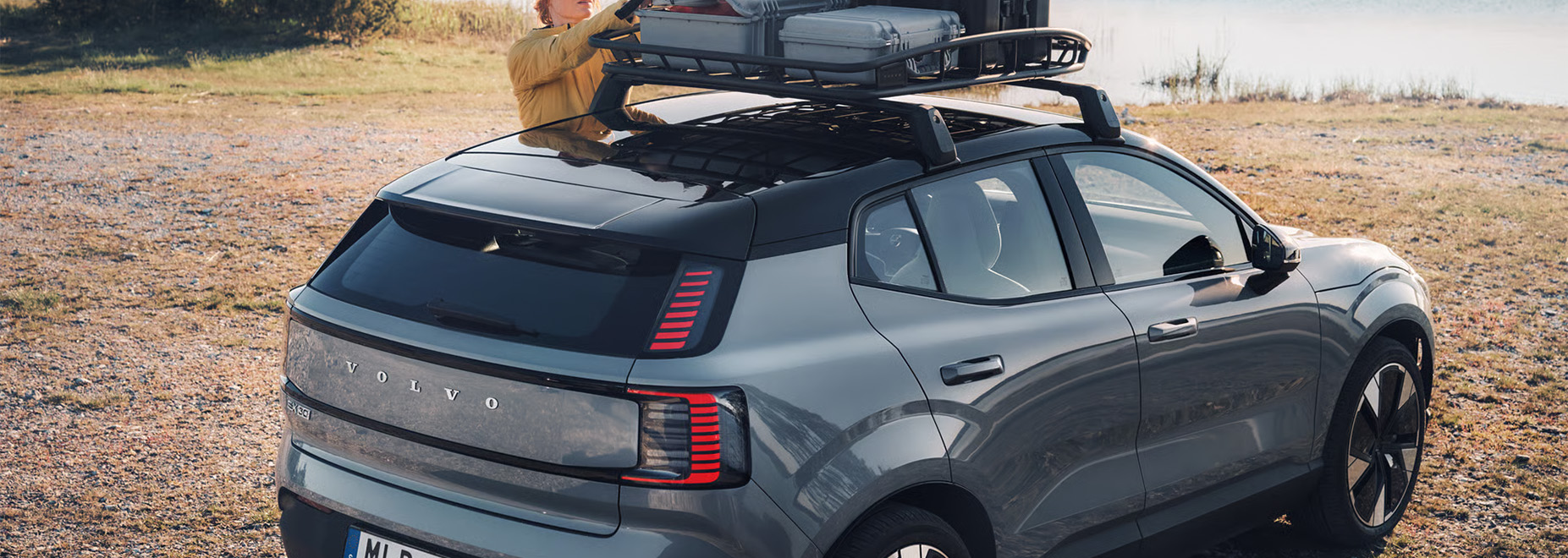 2026 Volvo EX30 at Delaney Volvo Cars Greensburg in Greensburg, PA | Woman. loading stuff on the roof rack of her 2026 Volvo EX30 2026 Volvo EX30 at Delaney Volvo Cars Greensburg in Greensburg, PA | Woman. loading stuff on the roof rack of her 2026 Volvo EX30
