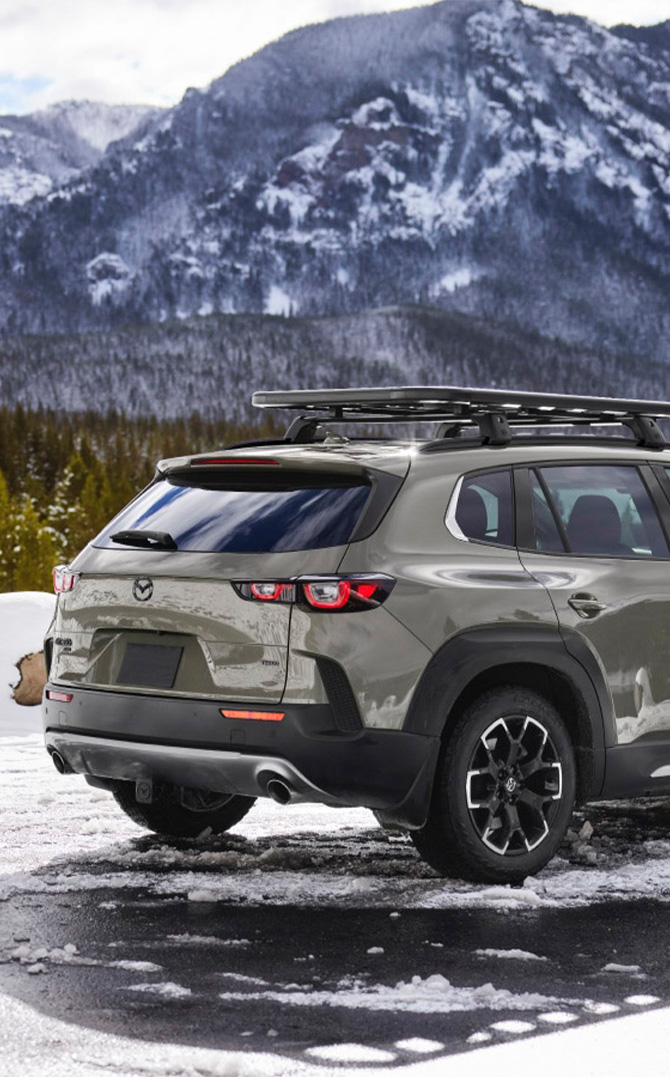 2026 Mazda CX-50 at Lancaster Mazda | Rear profile of a 2026 Mazda CX-50 parked near some snow 2026 Mazda CX-50 at Lancaster Mazda | Rear profile of a 2026 Mazda CX-50 parked near some snow