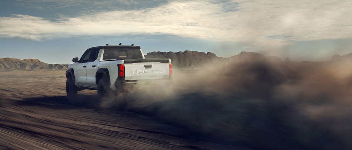 2026 Toyota Tacoma at Lancaster Toyota in East Petersburg, PA | Rear profile of a 2026 Toyota Tacoma driving fast off-road 2026 Toyota Tacoma at Lancaster Toyota in East Petersburg, PA | Rear profile of a 2026 Toyota Tacoma driving fast off-road