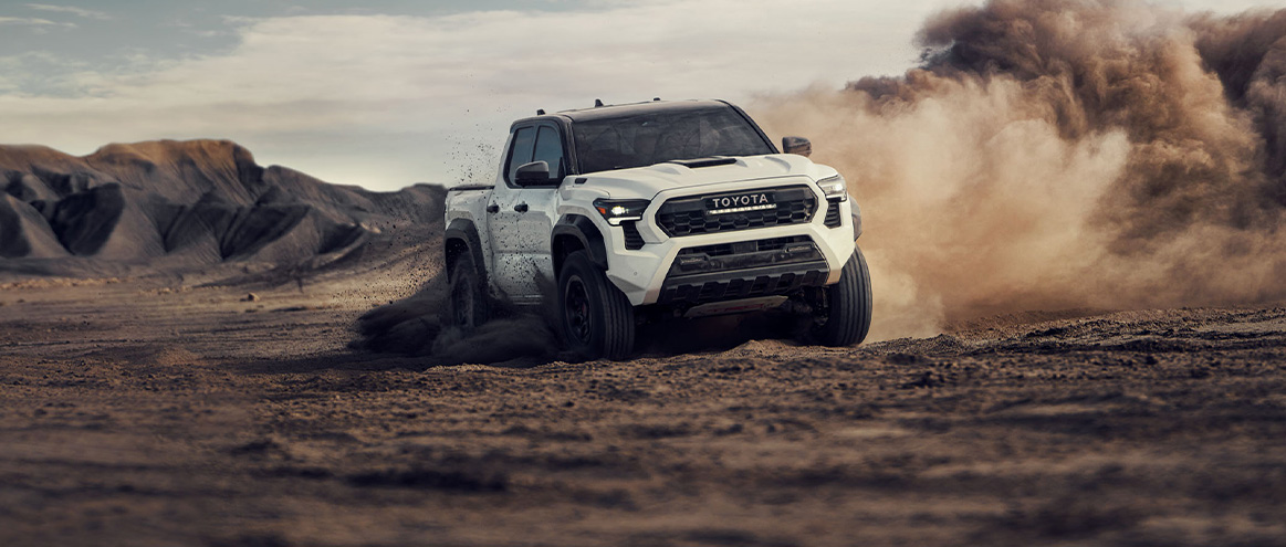 2026 Toyota Tacoma at Lancaster Toyota in East Petersburg, PA | White 2026 Toyota Tacoma driving in the dirt 2026 Toyota Tacoma at Lancaster Toyota in East Petersburg, PA | White 2026 Toyota Tacoma driving in the dirt