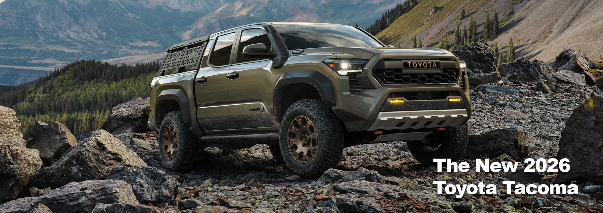 2026 Toyota Tacoma at Palmiero Toyota in Meadville, PA | green 2026 Toyota Tacoma parked on a pile of rocks on a hill