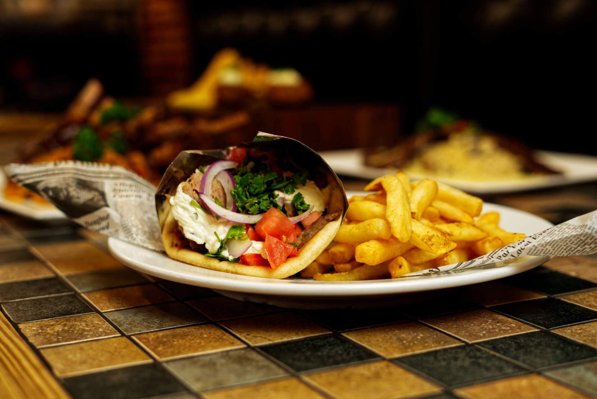 Signature gyros plated with sauces and fries