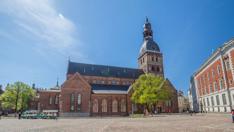 Exterior view of Riga Cathedral in Latvia, highlighting its impressive structure and surrounding landscape.