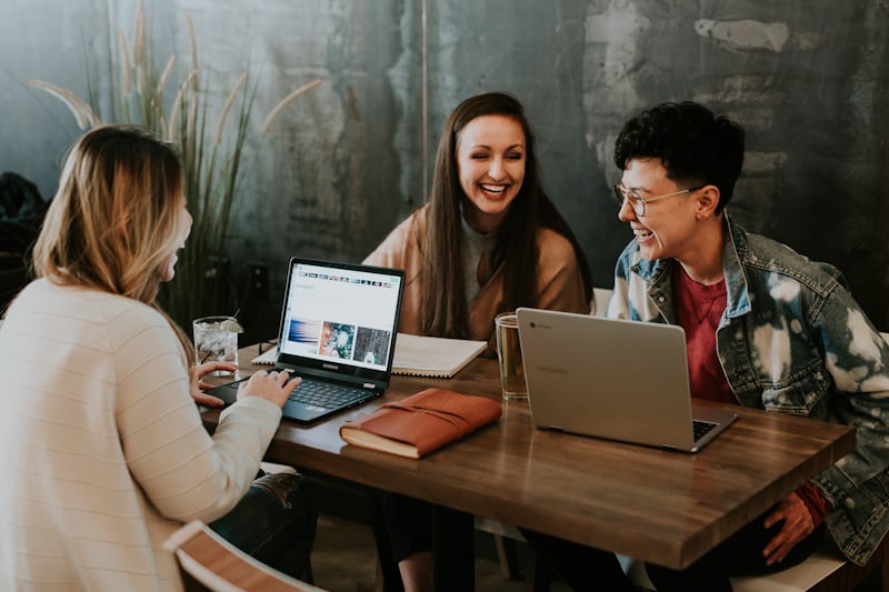 Teen student collaborating confidently with peers over a laptop