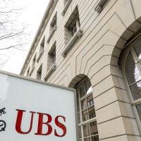 UBS profit halves as cost of old toxic debt mounts