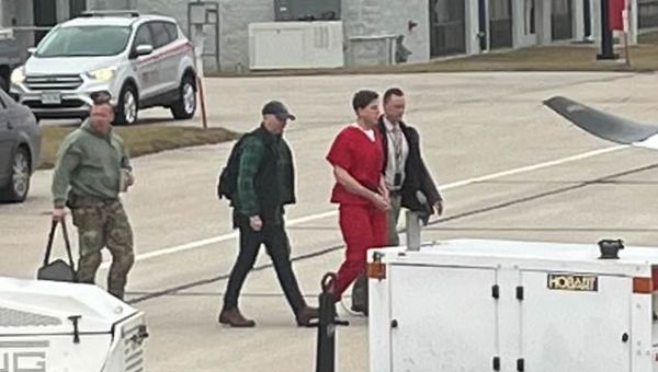 Quadruple murder suspect fitted with safety helmet arriving in Idaho