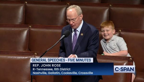 Rep John Rose’s son makes silly faces behind him during speech