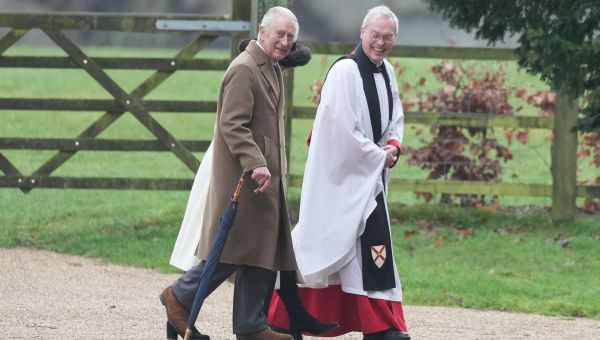 The King was seen wearing a brown coat and waving to the public before being greeted by the Rev Canon Dr Paul Williams