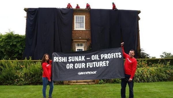Greenpeace activists drape Rishi Sunak’s £2m mansion in oil-black fabric after climbing on roof