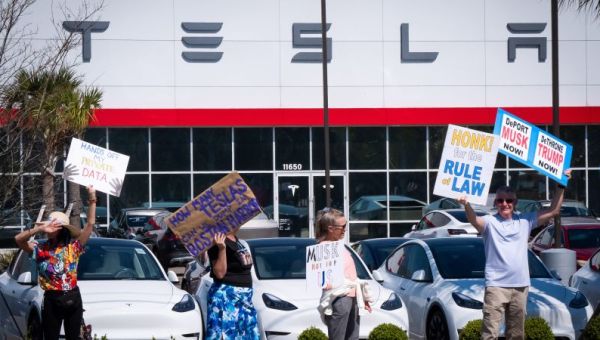 ‘Tesla Takedown’ protesters gather outside showrooms to rally against Elon Musk’s role with DOGE