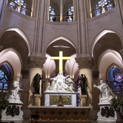 An archbishop’s knock formally restores Notre Dame to life as winds howl and heads of state look on