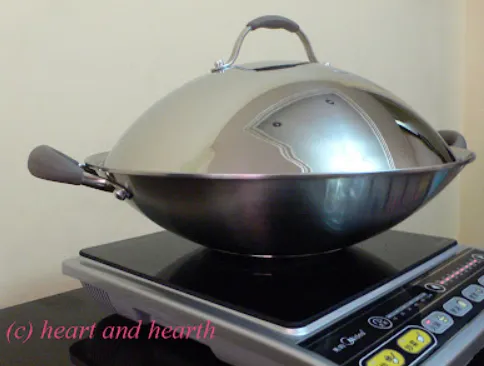 Flat-bottom wok positioned on modern induction cooking surface