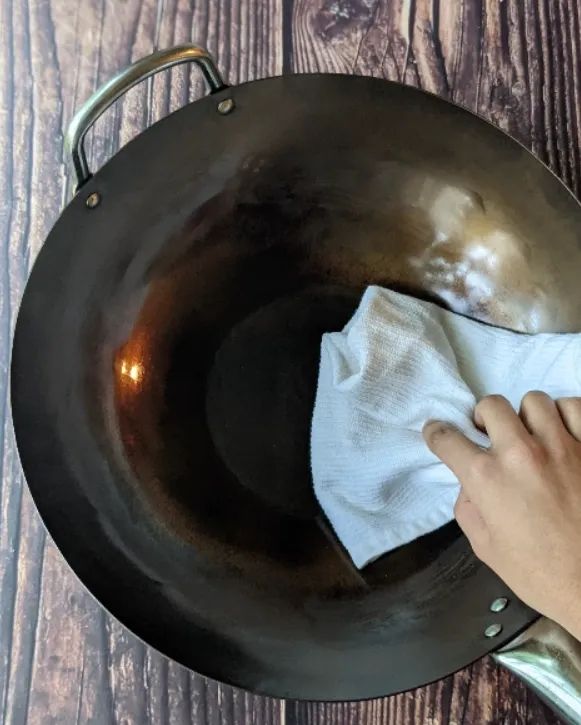 Perfectly seasoned carbon steel wok displaying the coveted black patina that improves with use