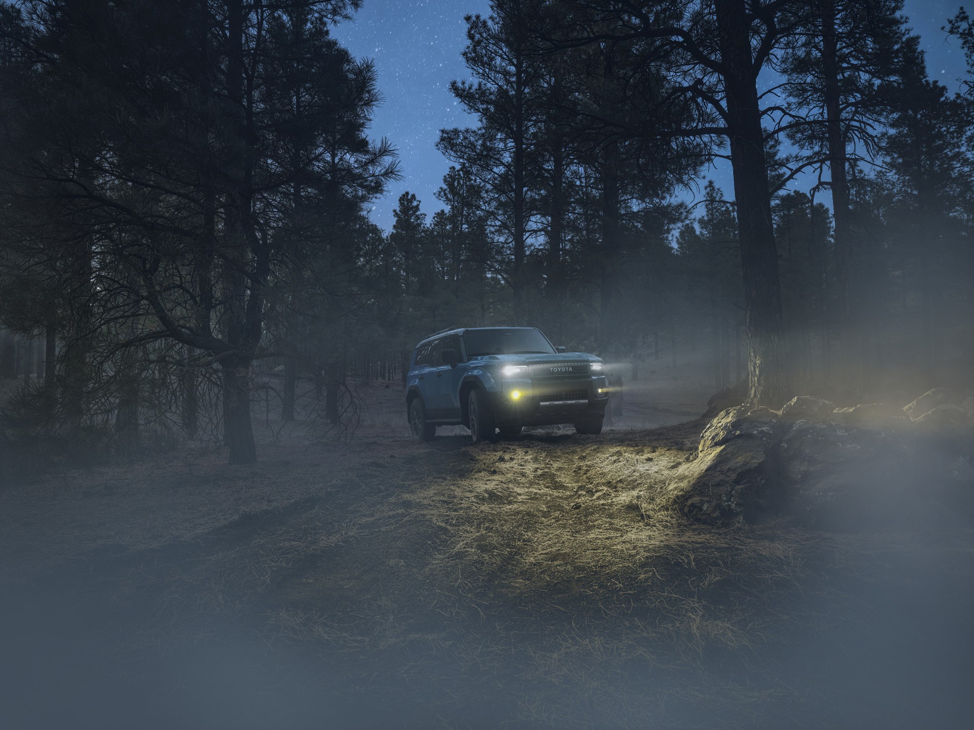 2026 Toyota Land Cruiser climbing rugged off-road terrain