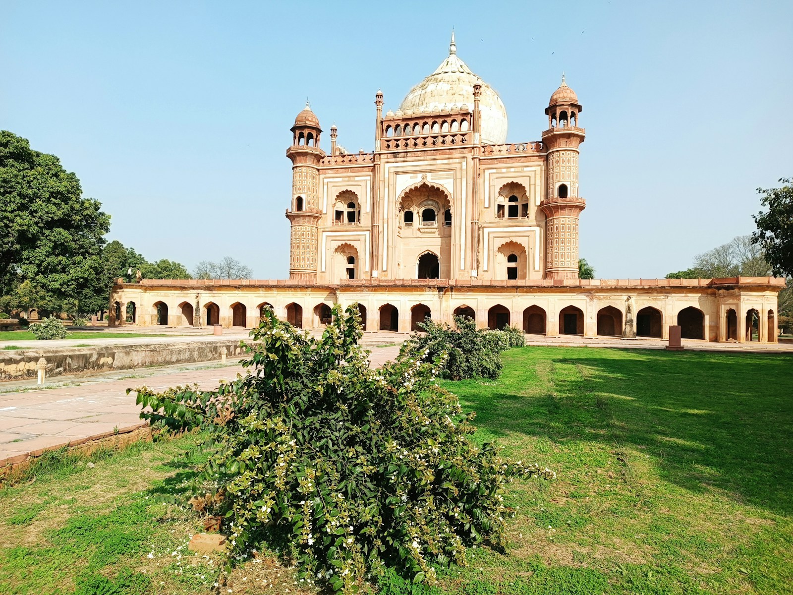 a large building with a dome and a lawn in front of it