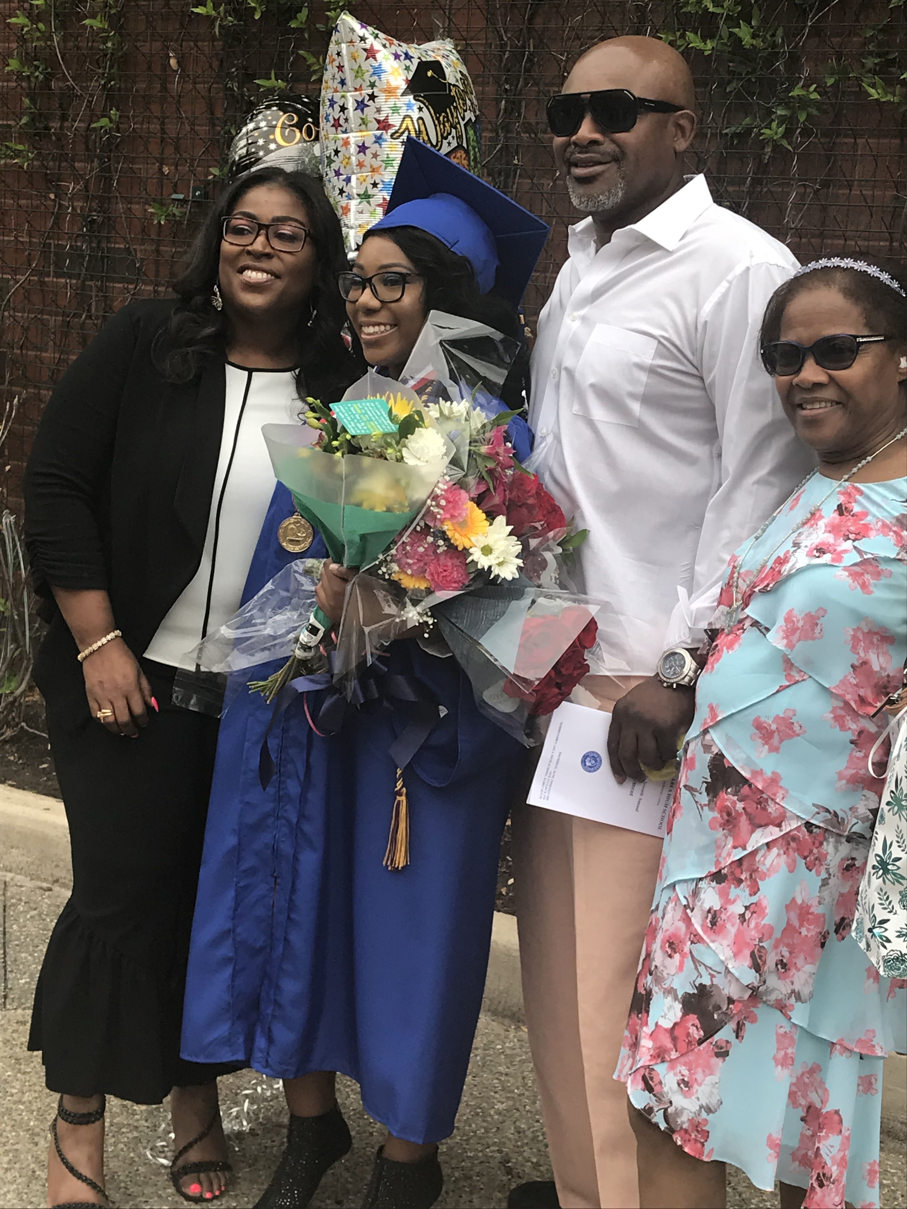 A family smiling with a graduate at graduation. 