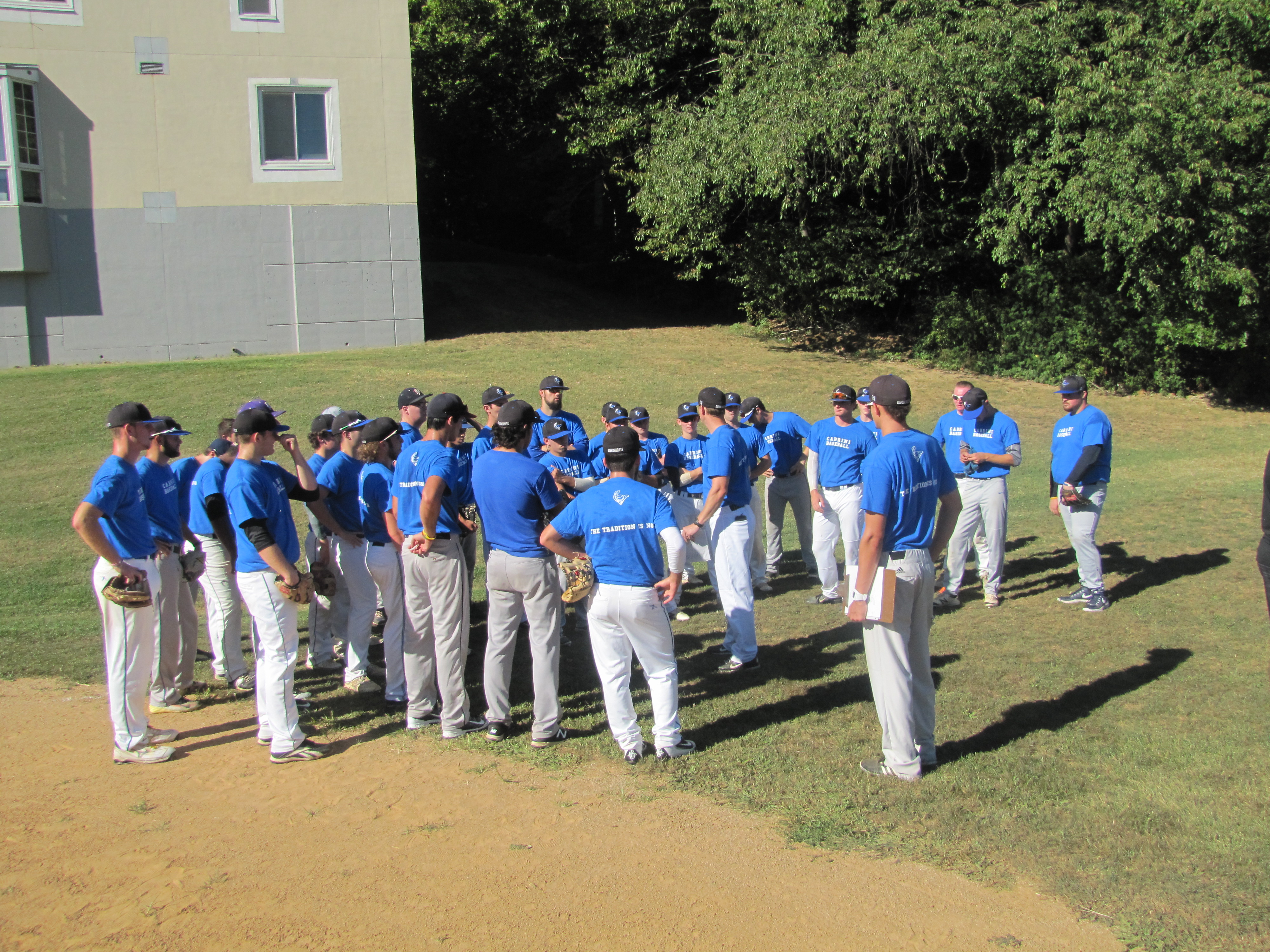 Photo shows Cabrini Baseball gathering together during practice 