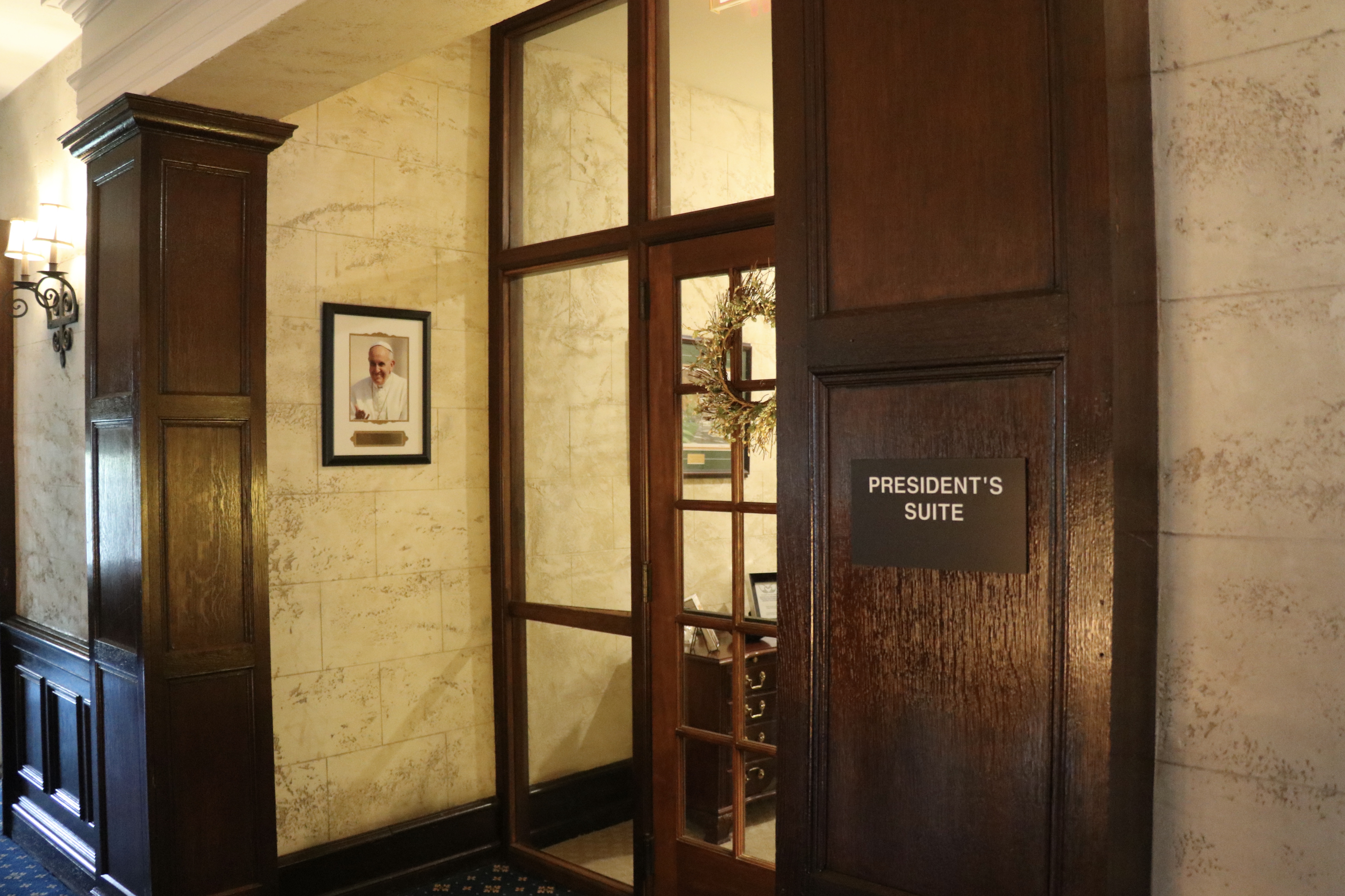 Cabrini's presidential suite located in the mansion. Glass door with brown trim and brown wood panels.