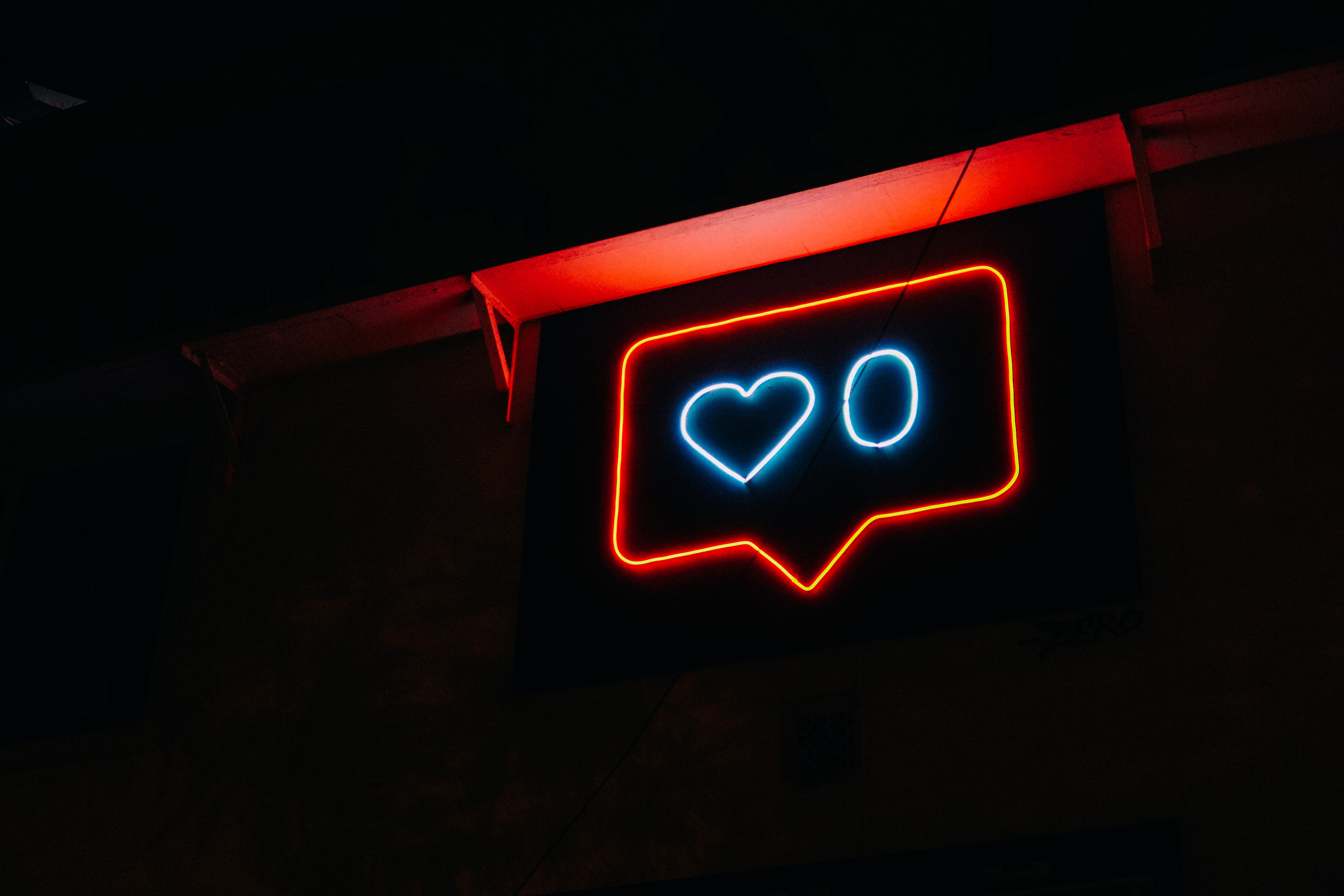 neon sign of a like icon with a heart and 0