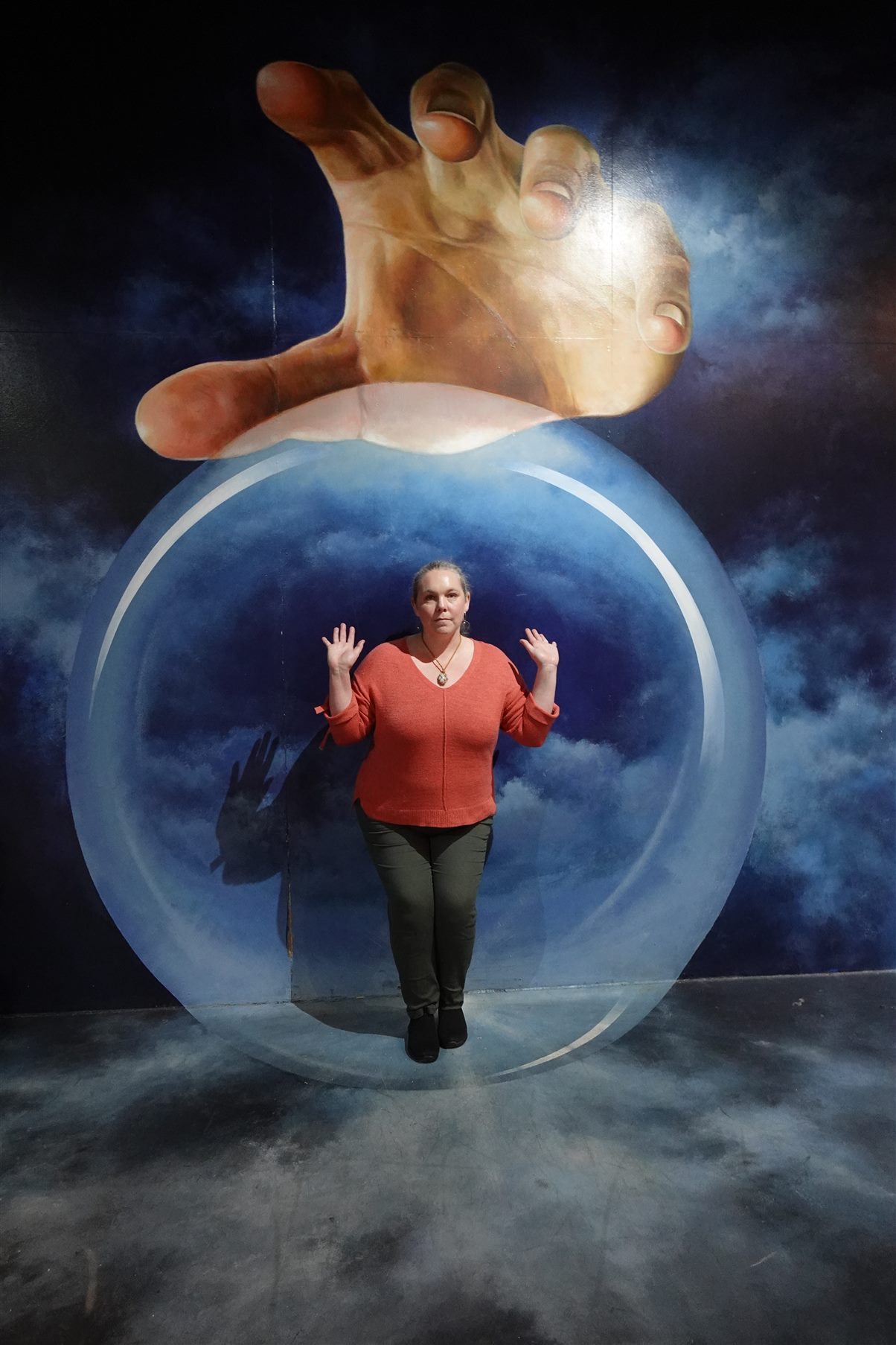 About 1 a woman standing in front of a mural