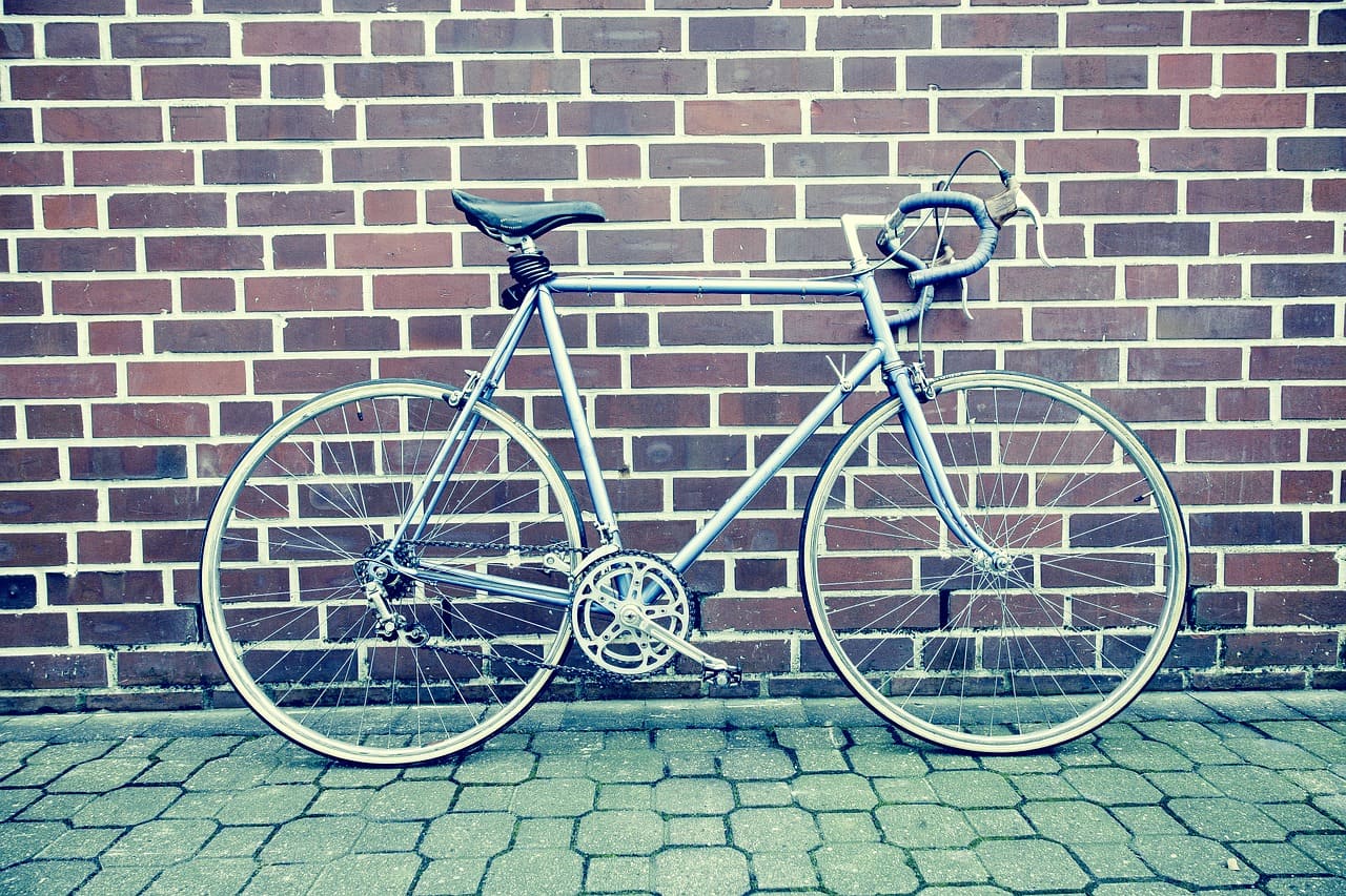A Road Bike With Dropped Handlebars Leaning Against A Brick Wall
