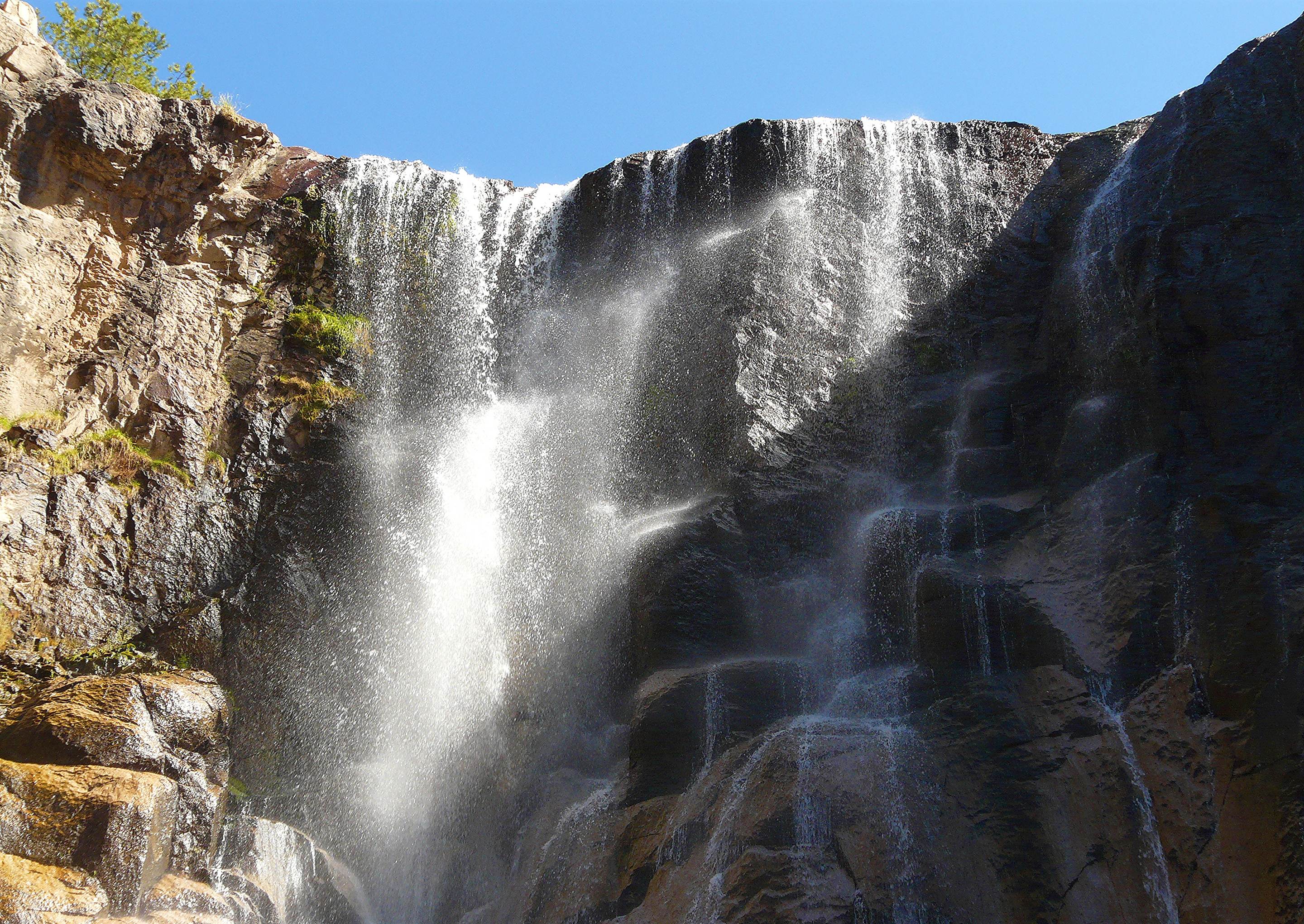 Cusarare waterfall dropping in white sheets over a dark rock ledge