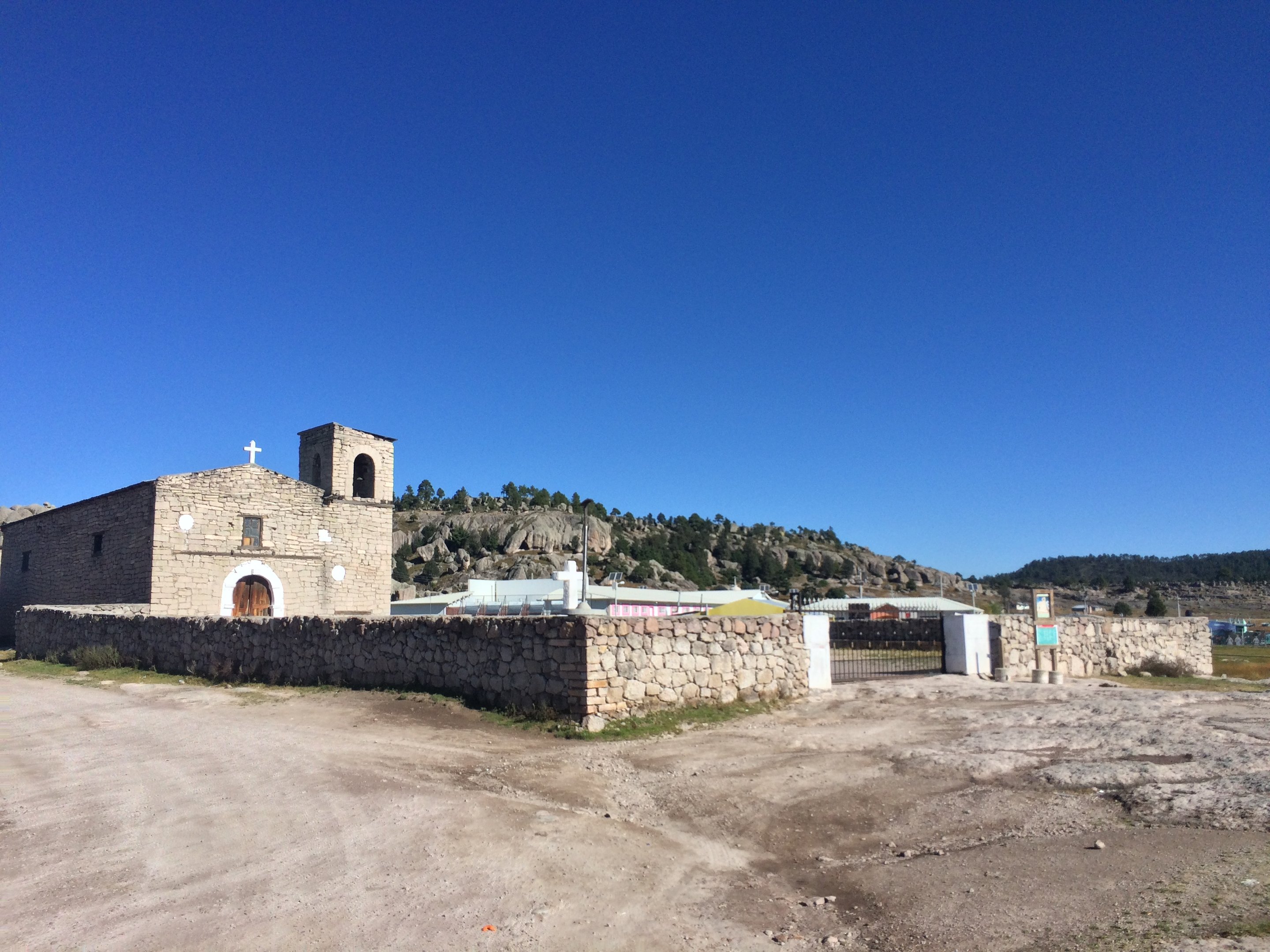 Die steinerne Mission San Ignacio de Arareko hinter ihrer Mauer, an einem unbefestigten Weg außerhalb von Creel