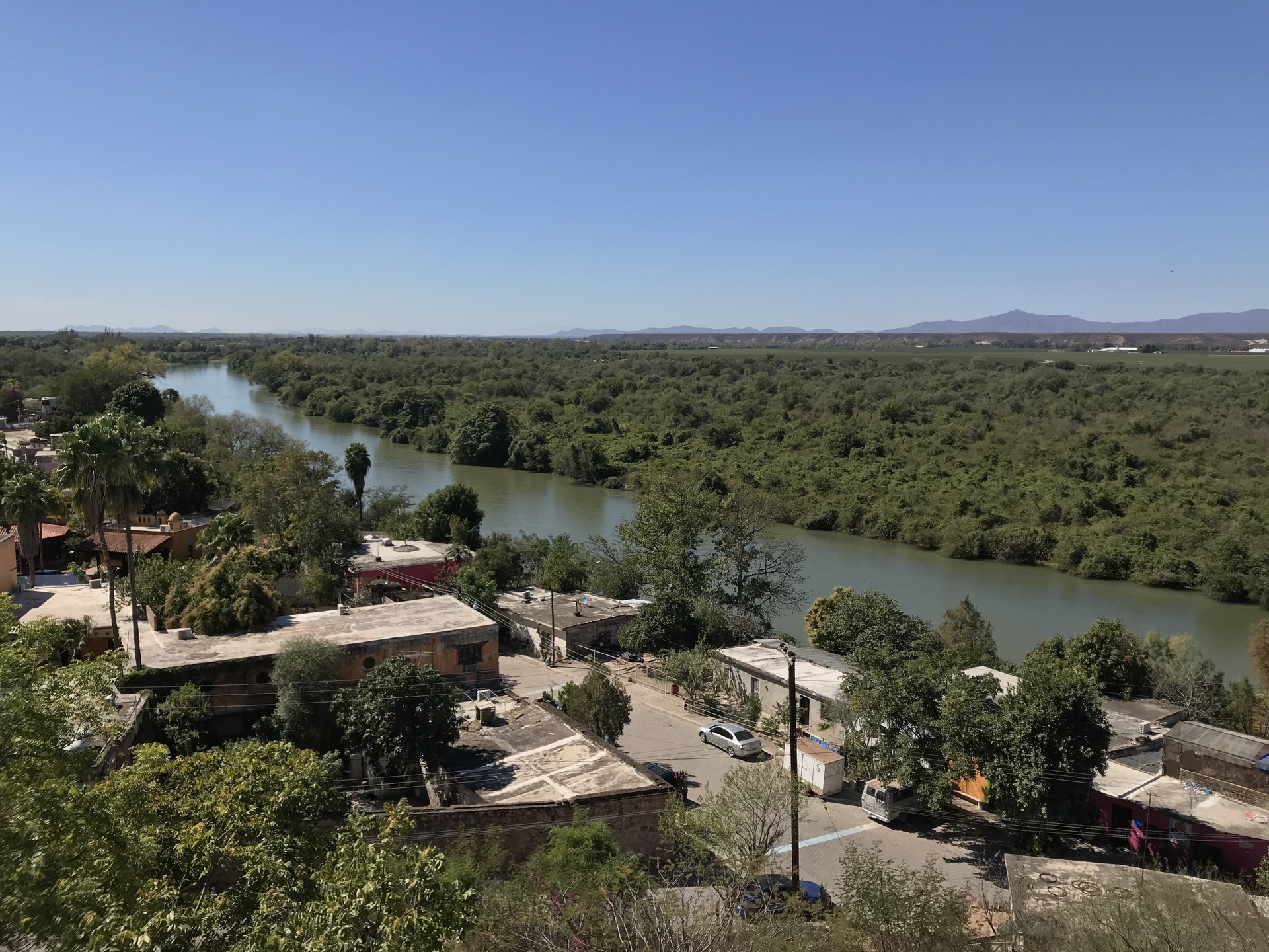 The river beside El Fuerte and the roofs at the edge of town, seen from above