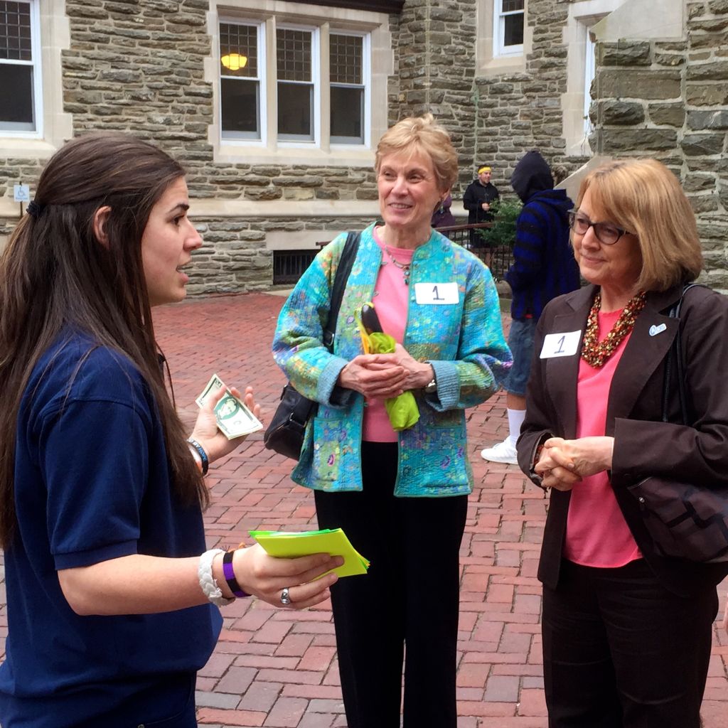 CRS Ambassador Emily Janny explains to CRS Executive Vice President Joan Rosenhauer how children are fleeing Latin America for their safety. Professor Suzanne Toton of Villanova University looks on.