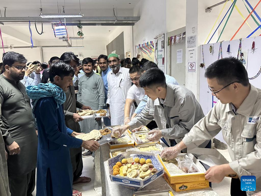 Chinese staff members of the Thar Coal Block-II Coal Electricity Integration project distribute food to Pakistani colleagues to celebrate Eid al-Fitr in the Thar Desert in Pakistan's