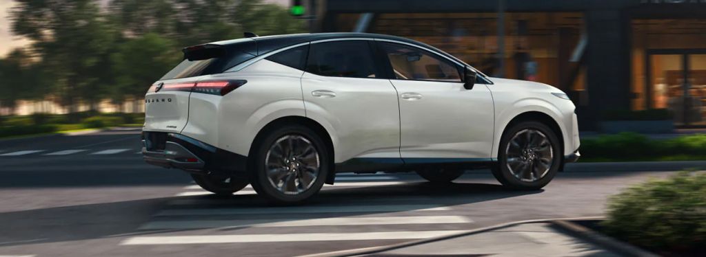 2025 Nissan Sentra at Delaney Nissan of Greensburg | side profile of a 2025 Nissan Murano driving by a city street