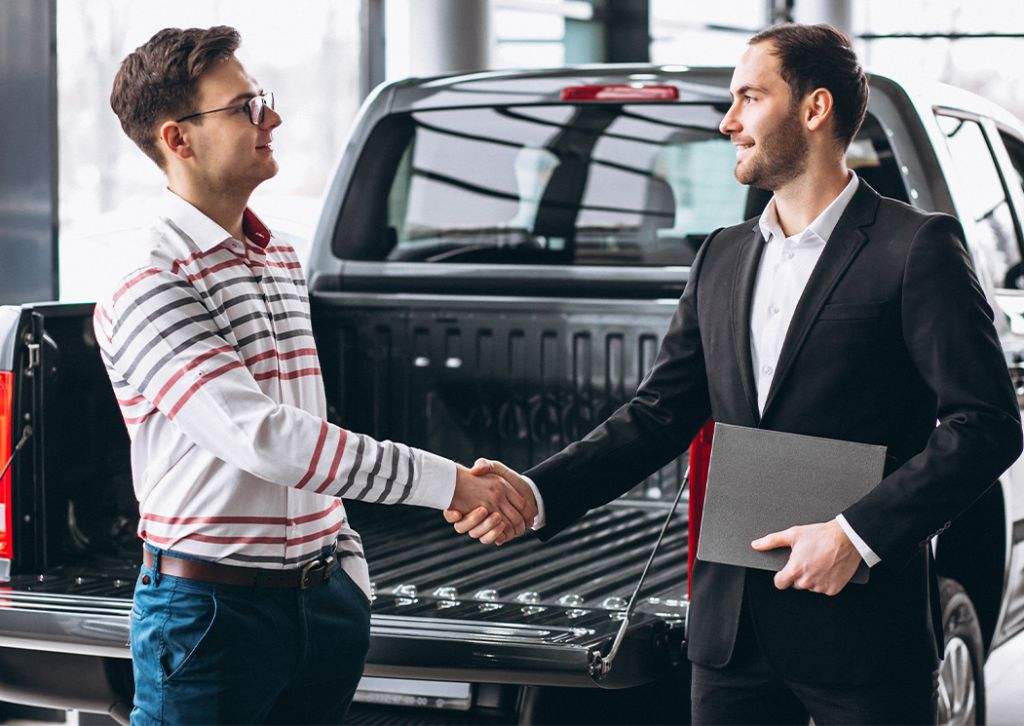 Trade in my leased car at Stetler DCJR in York, PA | Sales person shaking hands with customer inside of dealership