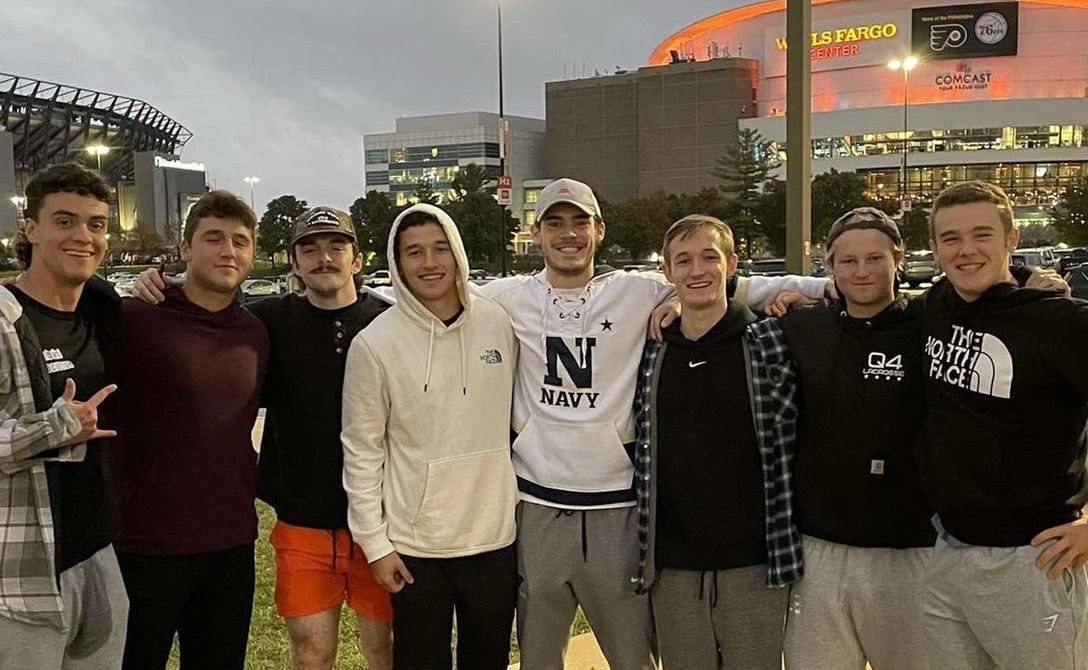 Hunter Waldron and eight of his friends outside of the Wells Fargo Center in the Philadelphia Stadium District. Lincoln Financial Field and the Wells Fargo Center sit in the backdrop as the sun sets before the Flyers home opener