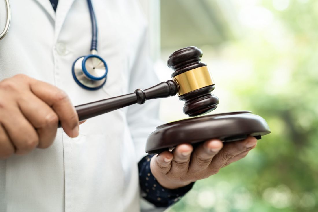 A close-up image of a gavel symbolises the legal consequences and potential for litigation in Factitious Disorder cases. The wooden gavel has a polished surface and a distinctive handle, representing the judiciary's authority. Its presence reflects the severe nature of legal proceedings that may arise from Factitious Disorder cases.