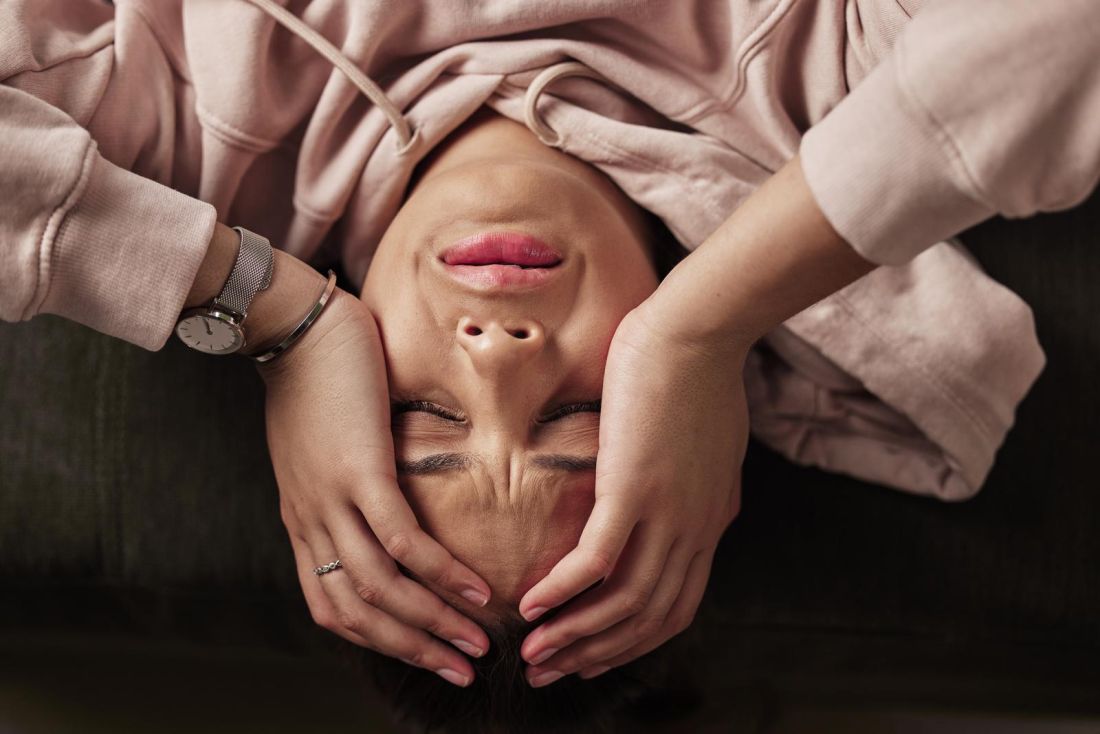 Sometimes it feels like you cant escape depression. High angle shot of an attractive young woman suffering from depression against a green background.