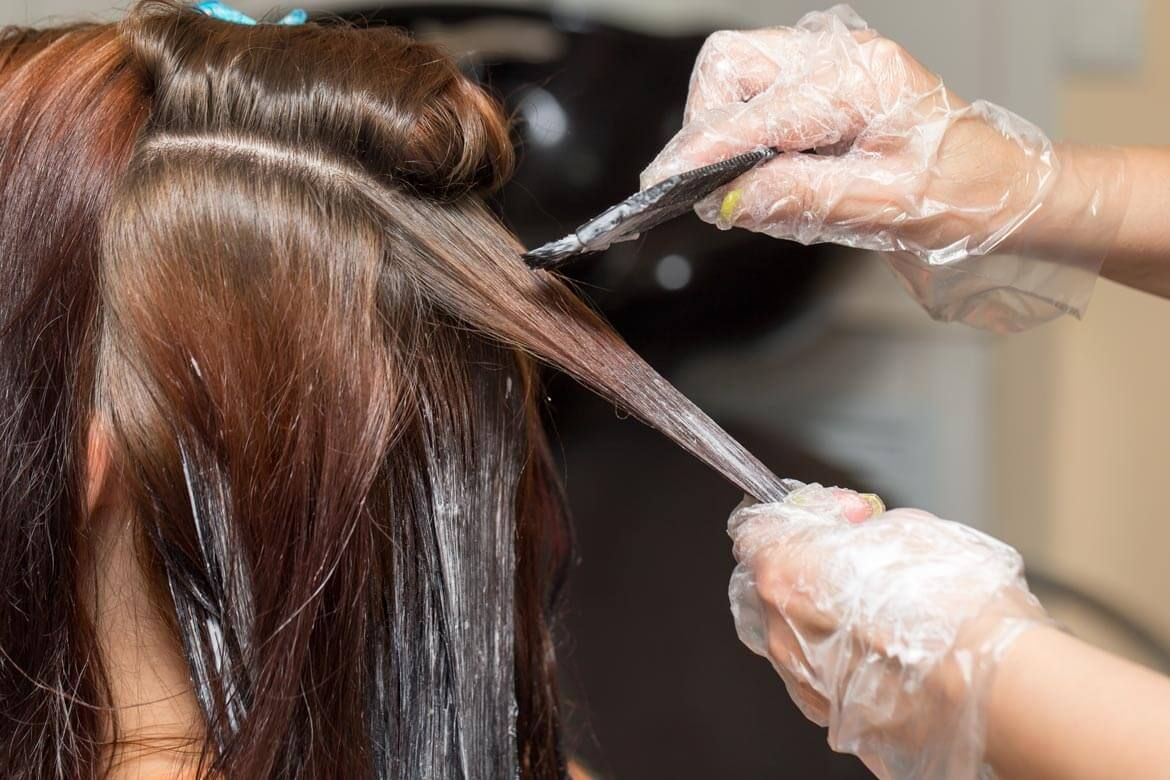 Ammonie-Free-Hair-Color Hairdresser coloring client's hair with comb
