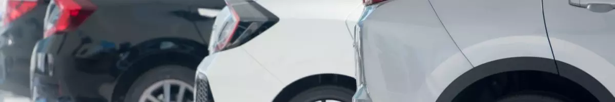 The back of 3 cars lined up in a row