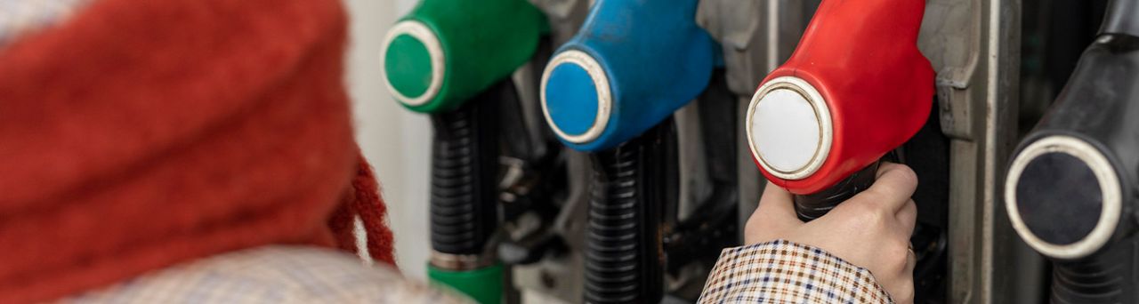 What Type of Gas is Best for My Car? | Lancaster Toyota in East Petersburg, PA | Person grabbing the red gas nozzle at the gas station