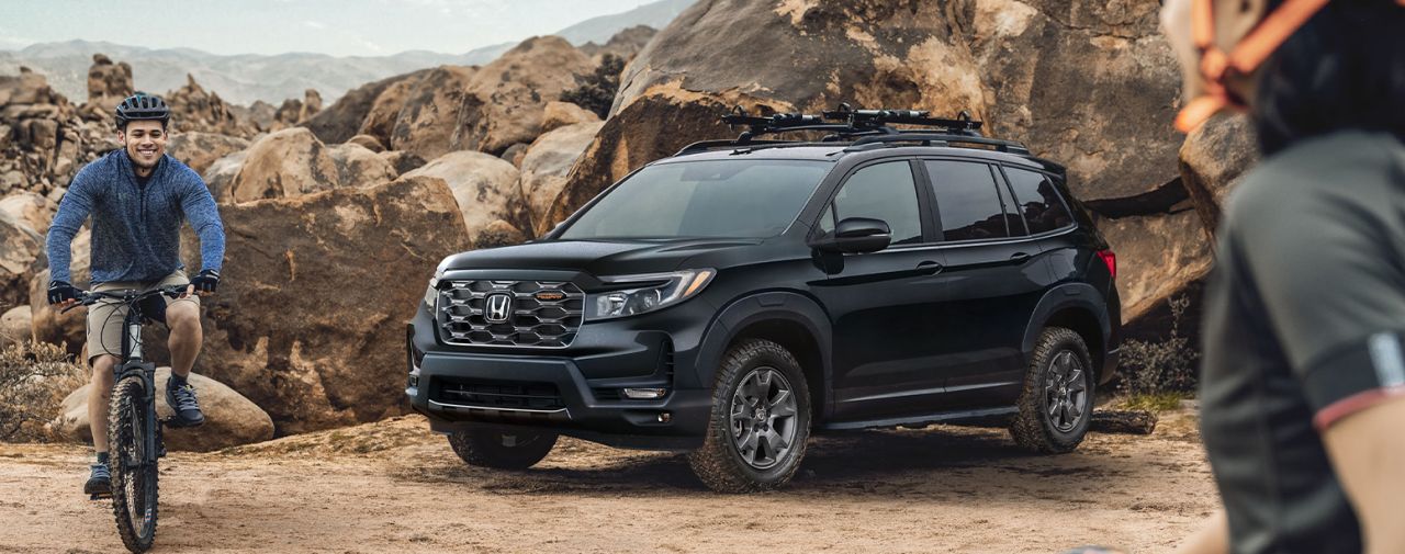 New 2025 Honda Passport at Delaney Honda | Two friends riding their bikes after parking their black color 2025 Honda Passport