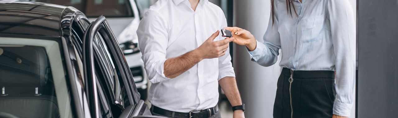 Why drivers should consider an extended warranty on their vehicle at Delaney CDJR of DuBois | Sales woman handing over new car keys to customer inside of dealership