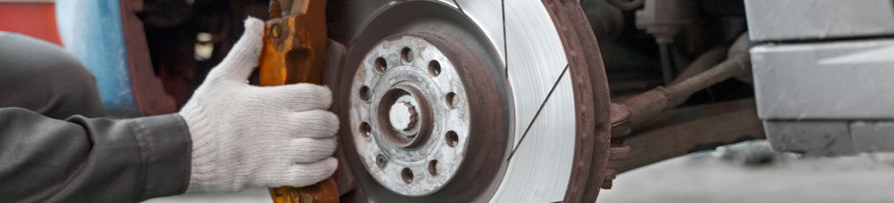 Brake replacement and Safety at Delaney Chevrolet of Greensburg | Mechanic with gloves about to start brake maintenance