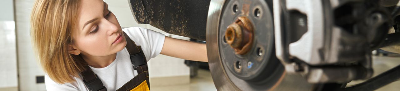 Brake replacement and Safety at Delaney Chevrolet of Greensburg | woman mechanic working on brake pads and rotors