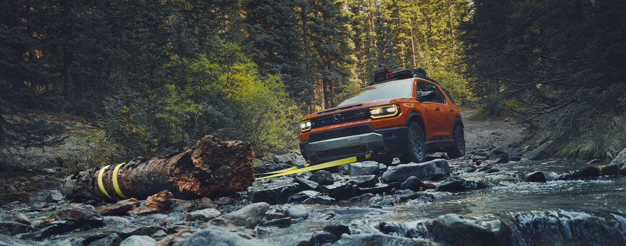 New 2026 Honda Passport at Delaney Honda | Orange Honda Passport towing a tree by the river