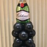 champagne bottle atop mini balloon column