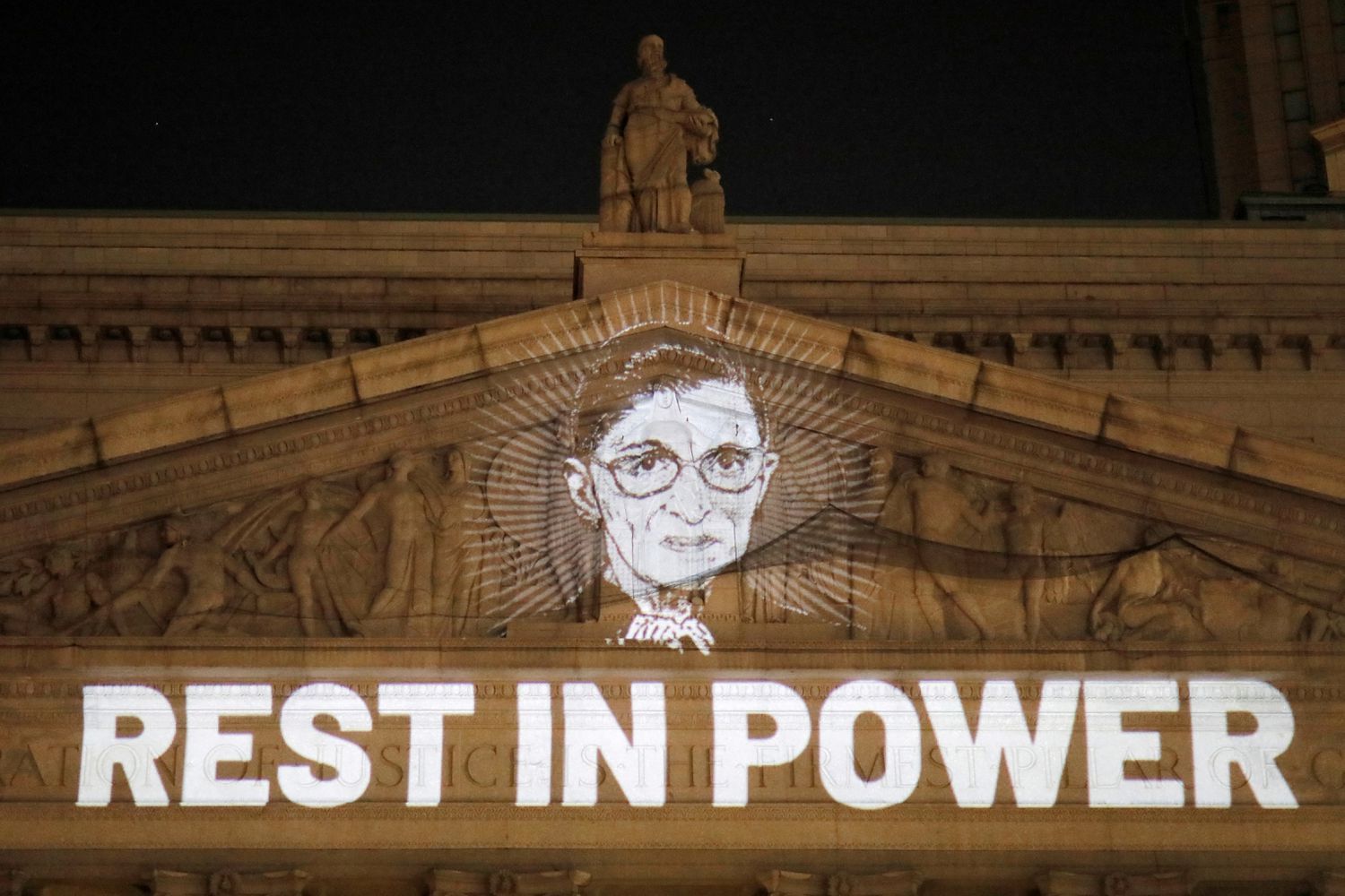 An image of Ruth Bader Ginsburg projected onto the New York State Civil Supreme Court building in Manhattan, New York City by Andrew Kelly