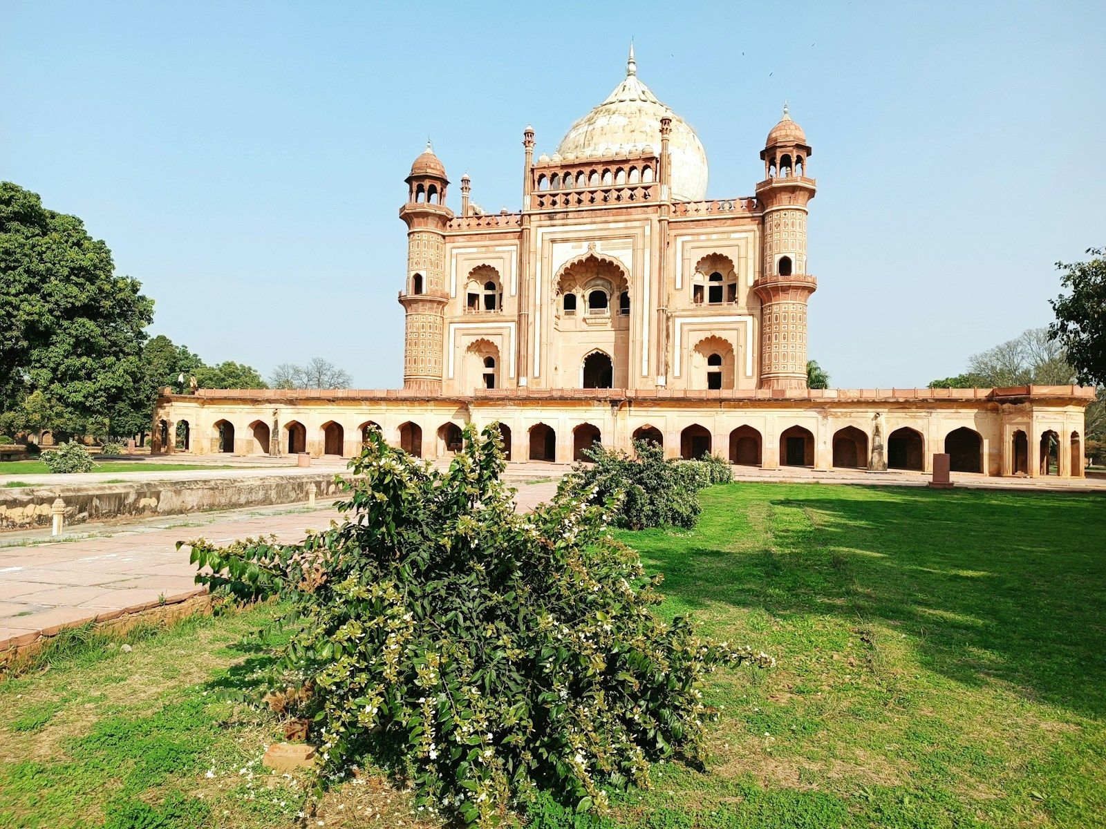 a large building with a dome and a lawn in front of it