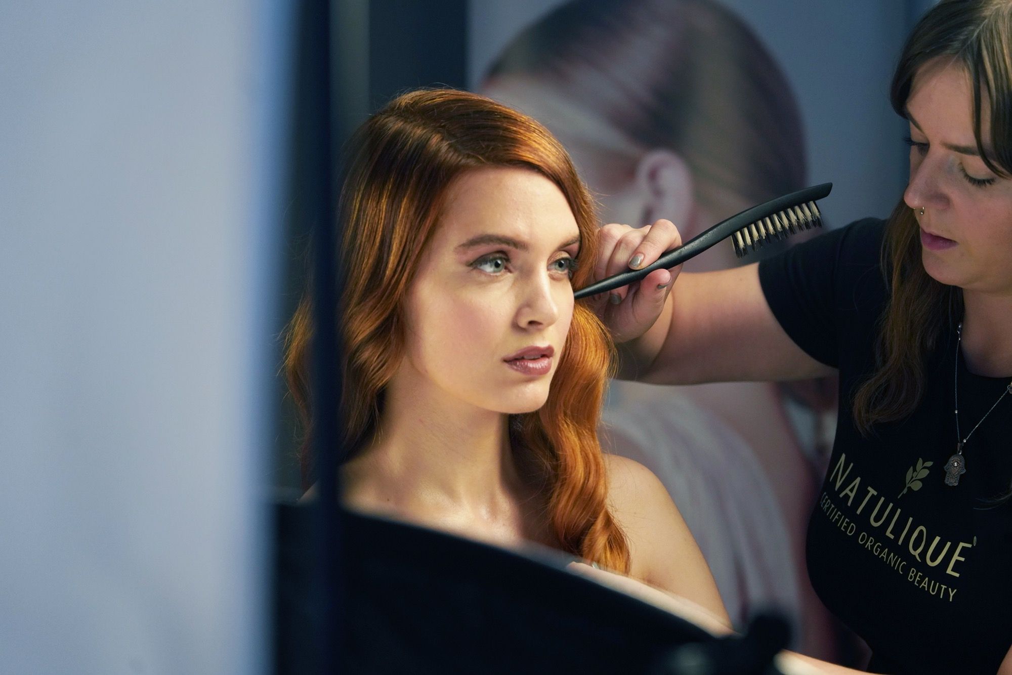 Styling and final touches An image of a woman's hair being styled in front of a mirror